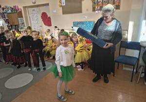 Pani dyrektor pasuje na starszaka dziewczynkę.