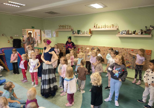Dziewczynki próbują zatańczyć według instrukcji osoby prowadzącej warsztaty.