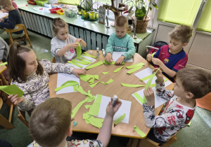 Dzieci tworzą trawę za pomocą techniki wydzieranki.