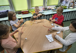 Dzieci tworzą rzeźby z kolorowych drucików kreatywnych i oplatają je folią aluminiową.