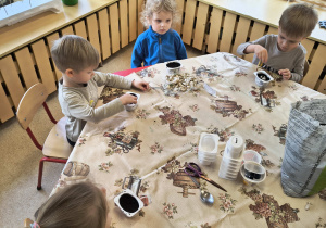 Dzieci przygotowują plastikowe kubeczki do wysadzenia cebulki.