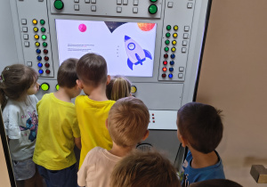 Dzieci słuchają ciekawostek o kosmosie.