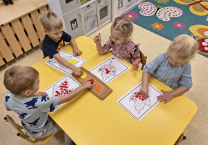 Dzieci malują listki farbami.