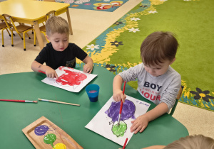 Dzieci malują farbami.