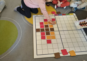 Dziewczynka komponuje jesienny obraz.