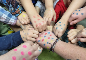 Dzieci prezentują dłonie ozdobione kropkami.