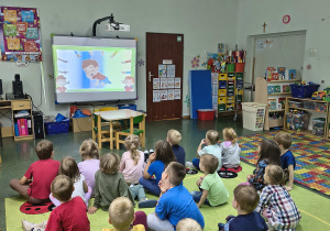 Dzieci oglądają film edukacyjny o kropce.