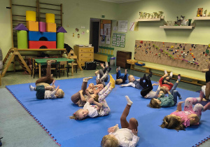 Dzieci ćwiczą rowerek.