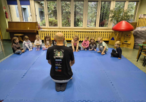 Dzieci słuchają instruktora judo.