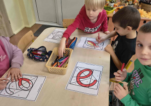 Chłopcy kolorują małą literę e według kodu.