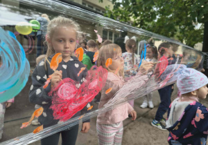 Dzieci malują farbami na folii.
