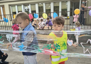 Dzieci malują farbami na folii.