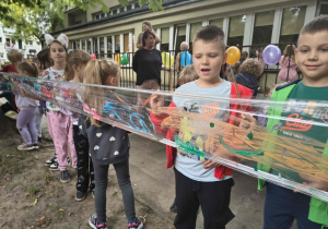 Dzieci malują farbami na folii.