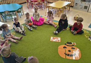 Dzieci oglądają ułożony obrazek dyni.