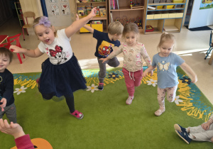 Dzieci stoją na jednej nodze.