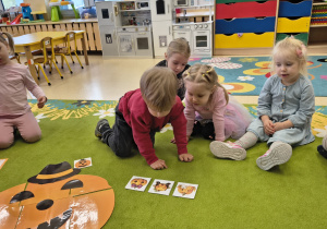 Chłopiec ogląda obrazki róznych dyni.