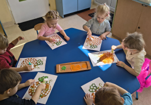 Dzieci malują farbami.