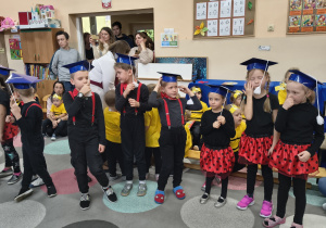 Starszaki prezentują się w biretach.