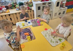 Dzieci tworzą duże kule z ciastoliny.