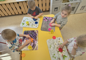 Dzieci robią placki z ciastoliny.