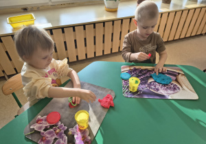 Dzieci tworzą kształty z ciastoliny za pomocą foremek.