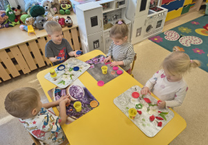 Dzieci tworzą okrągłe kształty z ciastoliny.