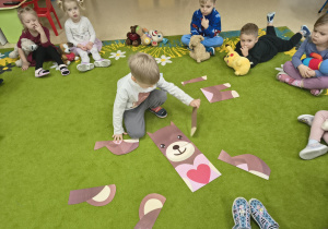 Chłopiec układa puzzle.