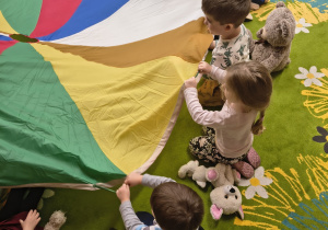 Dzieci uczestniczą w zabawie chustą animacyjną.