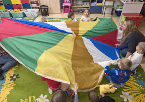 Dzieci chowają się pod chustę animacyjną.