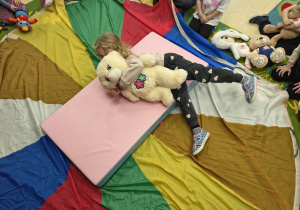 Dziewczynka turla się po materacu.