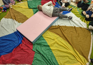 Chłopiec turla się po materacu.