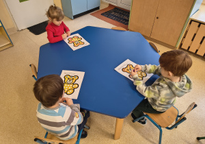 Dzieci wykonują misiową pracę plastyczną.