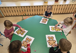 Dzieci wykonują pracę plastyczną z wykorzystaniem plasteliny.