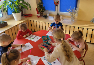 Dzieci kolorują mazakami malowanki.