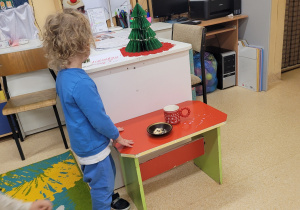 Chłopiec obserwuje pokruszone herbatniki i rozlane mleko przez Świętego Mikołaja.