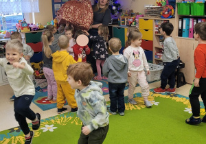 Wspólne przenoszenie paczki z prezentami spod choinki na podłogę.