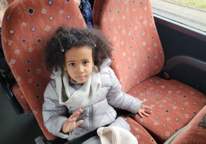 Dziewczynka z grupy Motylków macha do nauczyciela.