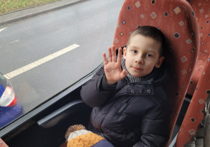 Chłopiec z grupy Motylków macha do nauczyciela.