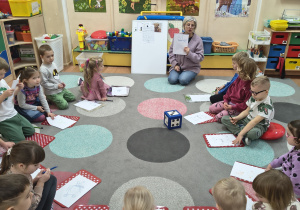 Nauczyciel wyjaśnia po kolei elementy rysowania misia.