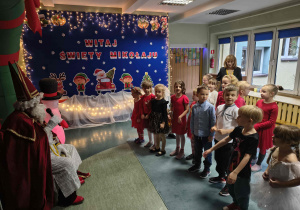 Dzieci recytują wiersz dla Mikołaja.