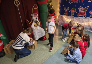 Marcel odbiera paczkę od Mikołaja.