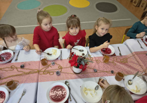 Zdjęcie dziewczynek przy świątecznym stole.