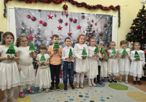 Zdjęcie grupowe dzieci z wykonanymi choinkami.