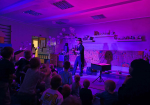 Dzieci oglądają pokaz bańkowych sztuczek.