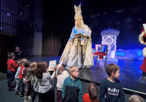 Aktorzy pomagają wręczać prezenty od Mikołaja.