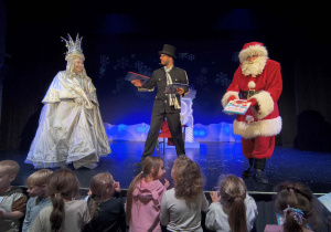 Mikołaj rozdaje dzieciom książki z okazji Mikołajek.