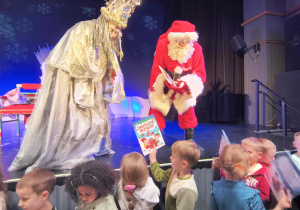 Mikołaj rozdaje książki dzieciom z grupy motylków.