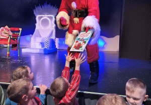 Dzieci z grupy motylków otrzymują książki.