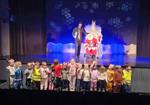 Grupa pszczółek na zdjęciu grupowym z Mikołajem i aktorami.