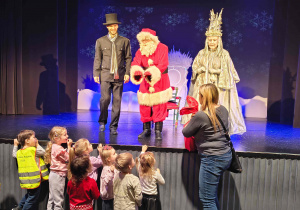 Pani Magda odbiera worek z prezentami od Mikołaja dla dzieci z grupy pszczółek.
